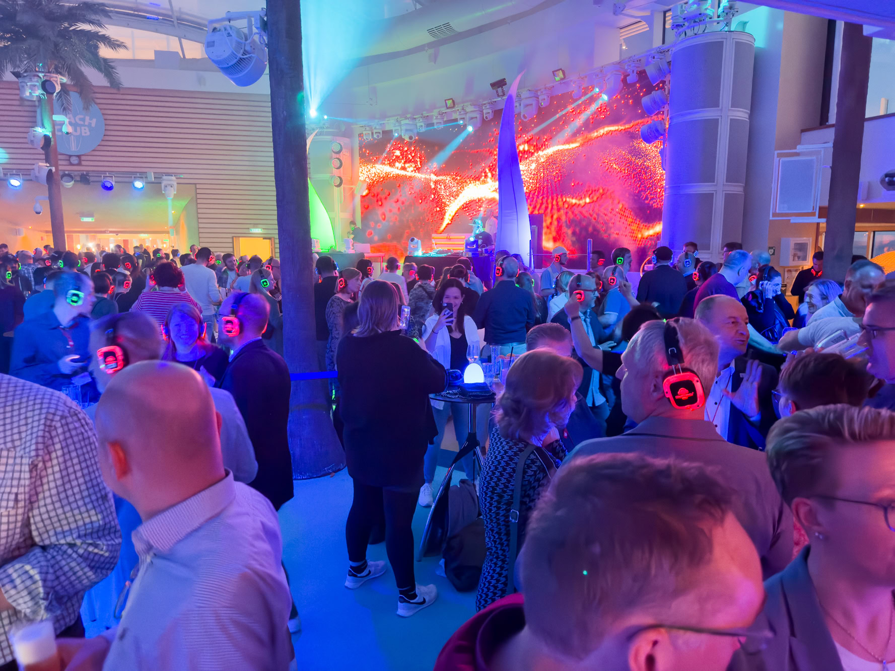 a large crowd of people in a large room with a stage and lights