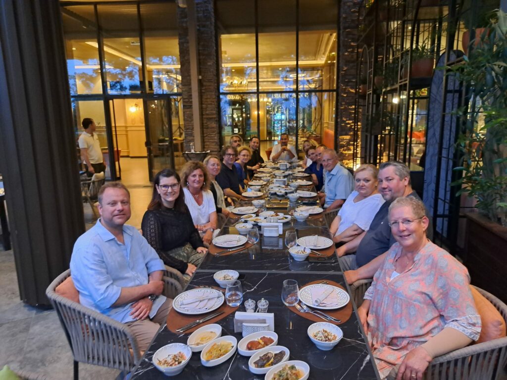 a group of people sitting at a table with food on it