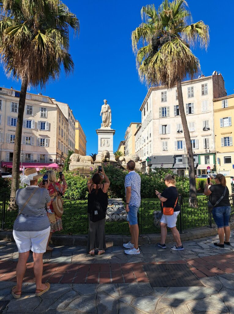 a group of people taking a picture of a statue in a city