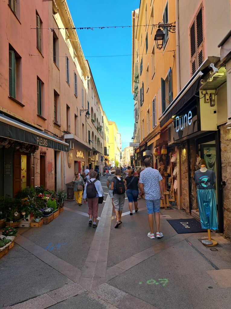 people walking down a street with people and shops