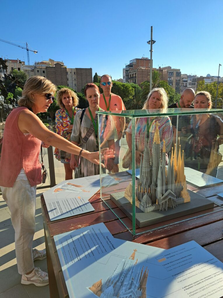a group of people looking at a model of a tower