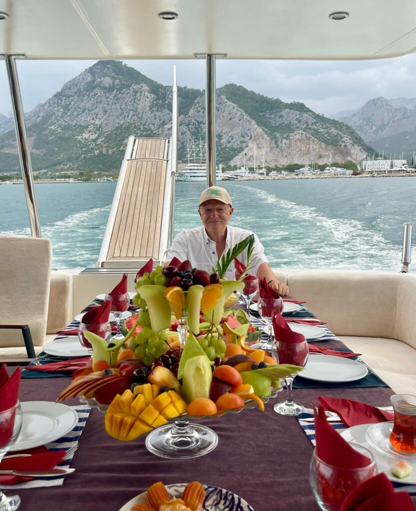 a man sitting at a table with fruit on it