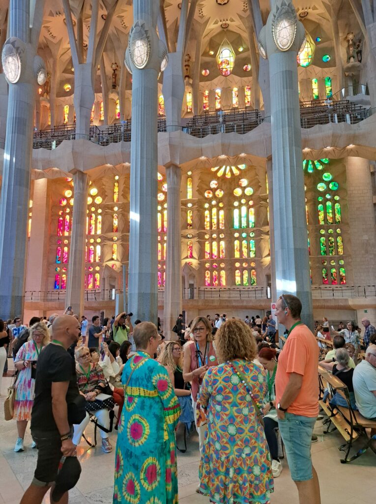 a group of people in a large room with columns and stained glass windows