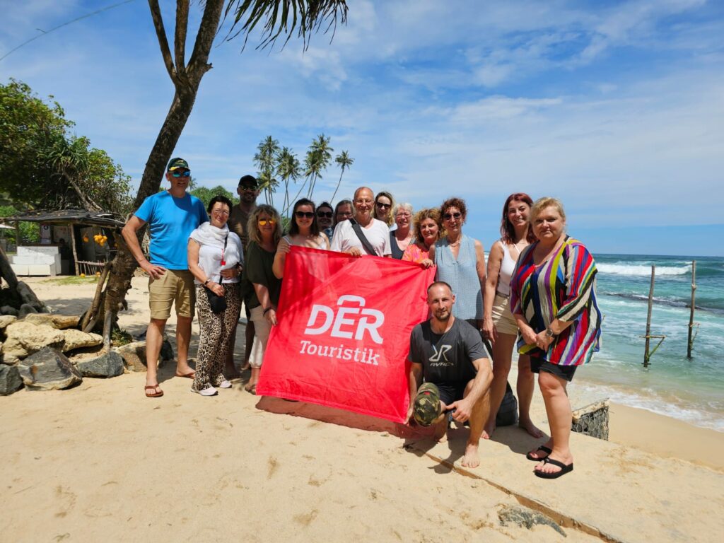 a group of people posing for a photo on a beach